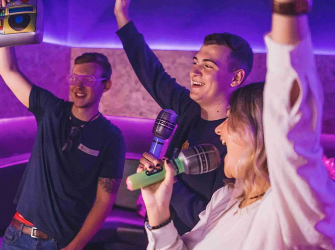 A group singing in a Boom Box Karaoke booth