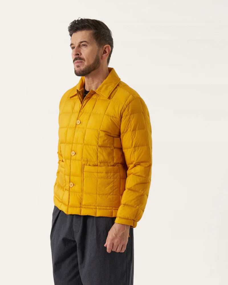 Mustard quilted down jacket over charcoal pleated trousers, from Uniform Buffalo