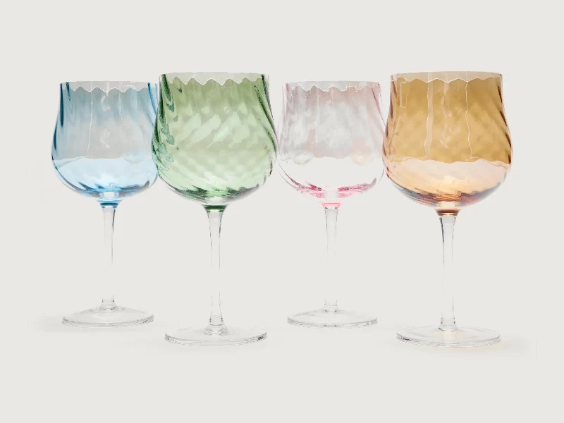 Four coloured wine glasses in blue, green, pink and amber