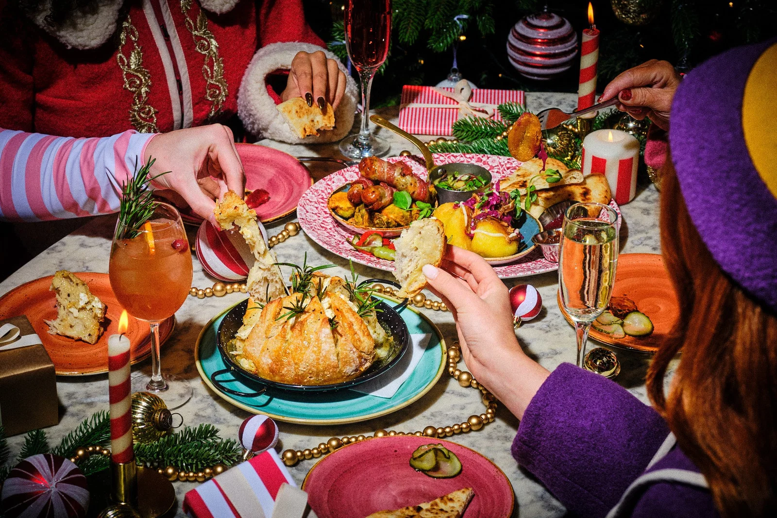 Friends sharing a festive table at Bill’s, with a baked sharing centrepiece, pigs in blankets and flatbread