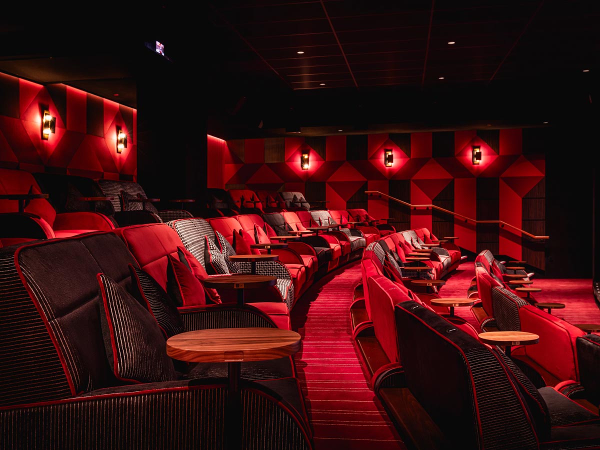 Red sofas and side tables in an Everyman screen