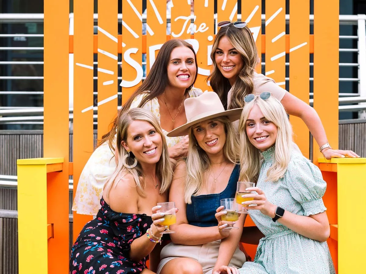 A group of friends with drinks in the sunshine at Bond Street